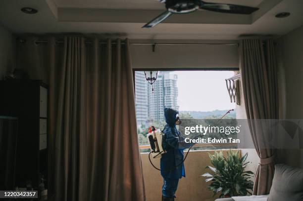 une femme en combinaison de protection pulvérisant et désinfectant le virus antiparasitaire exterminateur de balcon - animaux nuisibles photos et images de collection