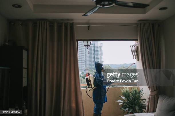 one woman in protective suit spraying and disinfecting the balcony exterminator pest control virus - pest stock pictures, royalty-free photos & images
