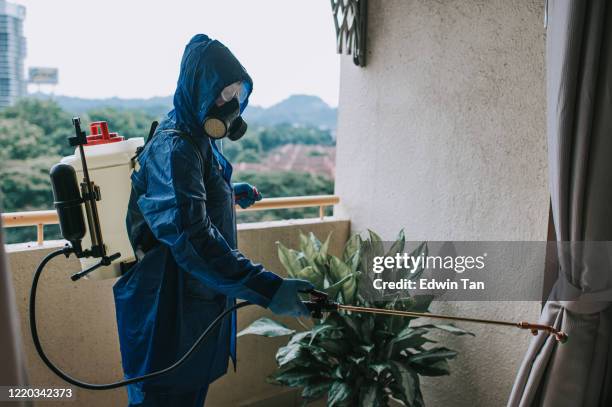 one woman in protective suit spraying and disinfecting the balcony exterminator pest control virus - pest stock pictures, royalty-free photos & images