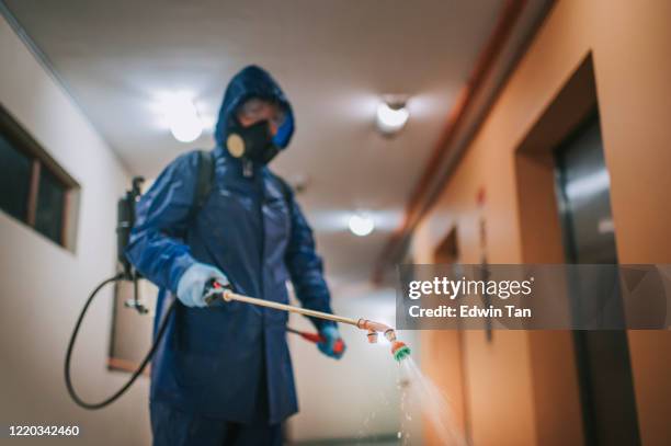 one woman in protective suit spraying the house and disinfecting the corridor exterminator pest control virus - pest control equipment stock pictures, royalty-free photos & images