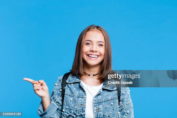 happy teenge girl pointing with finger at copy space - teenage hand signs stock pictures, royalty-free photos & images