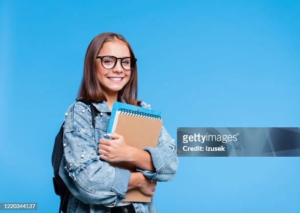 portrait of female high school student holding books - large rucksack stock pictures, royalty-free photos & images