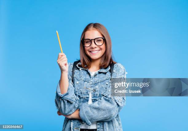 portrait of petty teenage girl poinitng with pencile - student coloured background stock pictures, royalty-free photos & images