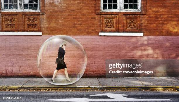 businesswoman in a bubble walking on sidewalk. - protection stock pictures, royalty-free photos & images