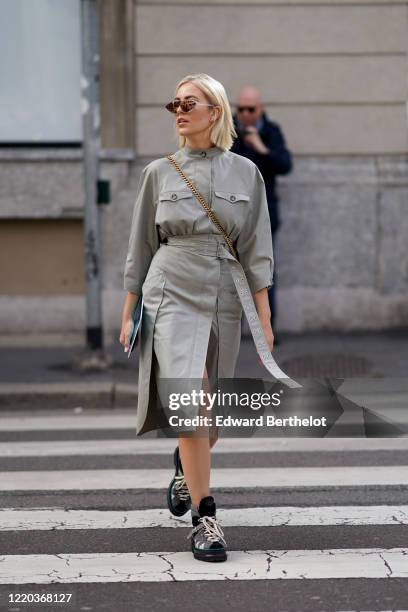 Guest wears mirror sunglasses, a gray dress, black shoes with white shoelace, a crossbody bag with a golden chain, outside Sportmax, during Milan...