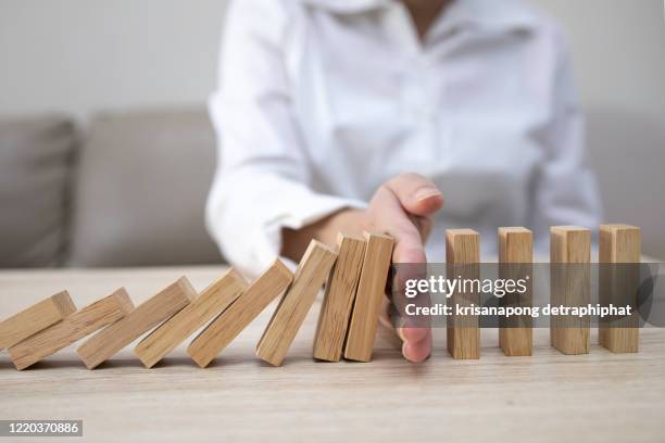 business man placing wooden block on a tower concept risk control, planning and strategy in business.alternative risk concept,risk to make buiness growth concept with wooden blocks - risico stockfoto's en -beelden