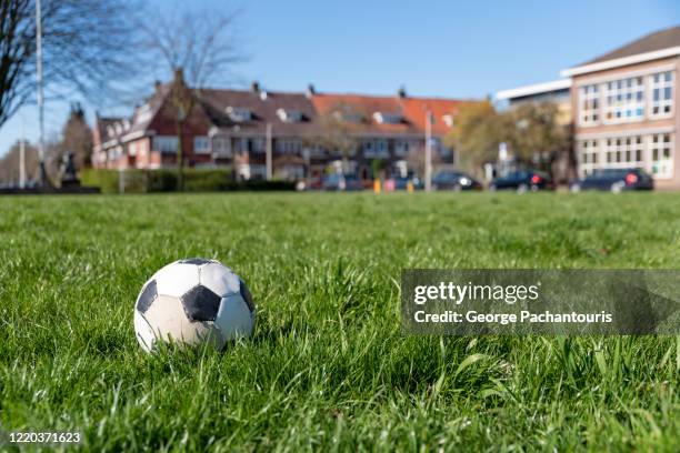 soccer ball on a grass field in a residential area - kids' soccer stock pictures, royalty-free photos & images