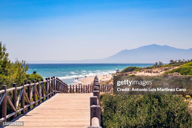 cabopino beach in the municipality of marbella, malaga. wooden walkway to the beach. - malaga fotografías e imágenes de stock
