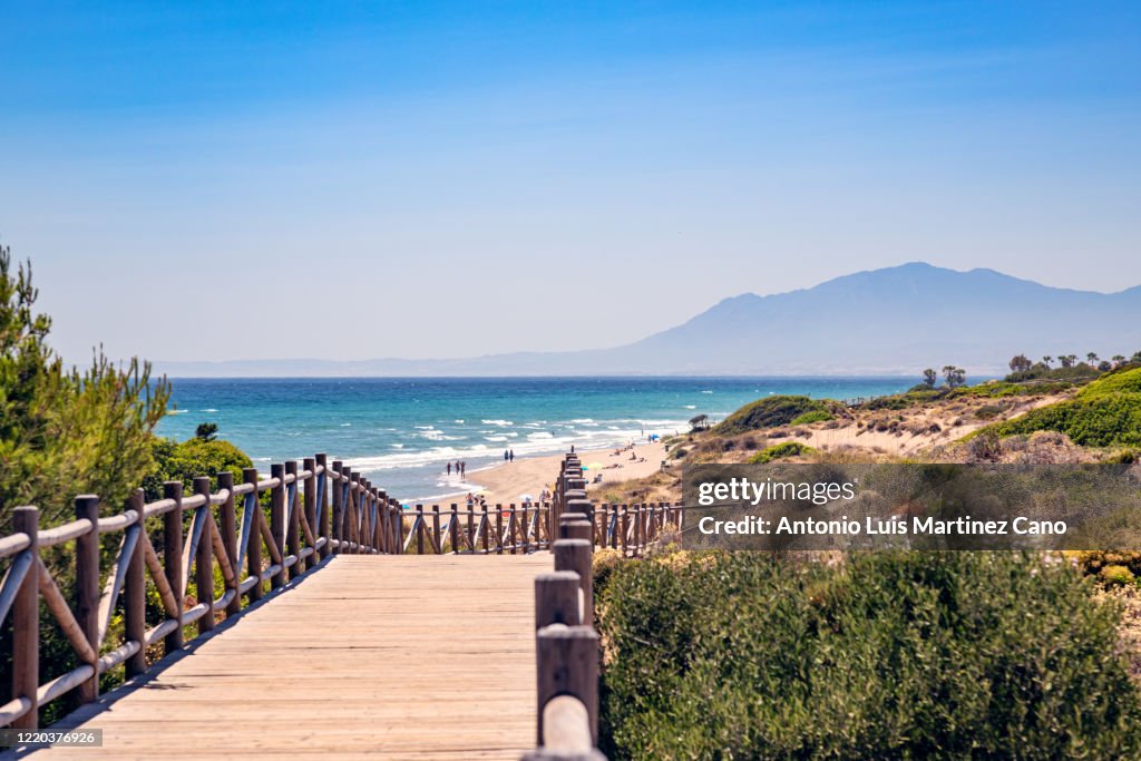 Cabopino beach in the municipality of Marbella, Malaga. Wooden walkway to the beach.