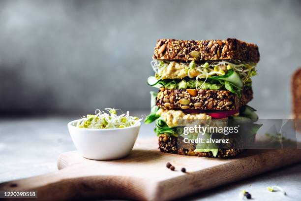 veganes super-sandwich mit sprossen serviert - snacks stock-fotos und bilder