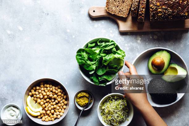 chef bereitet veganes sandwich zu - table top view stock-fotos und bilder