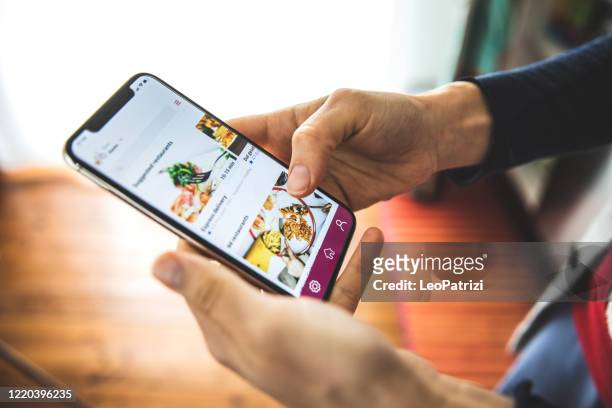 donna che ordina cibo con la consegna di app mobili a casa al momento del distanziamento sociale - applicazione mobile foto e immagini stock
