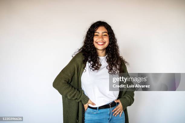 cheerful young woman standing on white background - woman wearing white jeans ストックフォトと画像