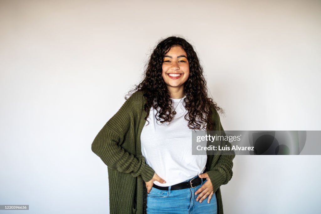 Cheerful young woman standing on white background