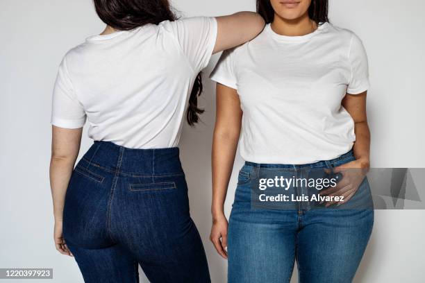 two women standing in opposite directions - woman jeans stock pictures, royalty-free photos & images