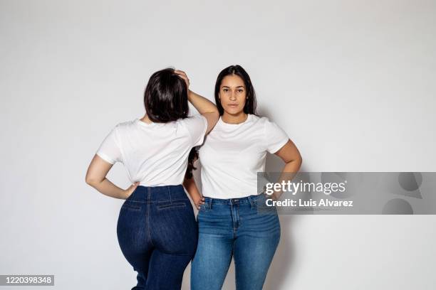 two plus size female standing in opposite directions - formes généreuses photos et images de collection