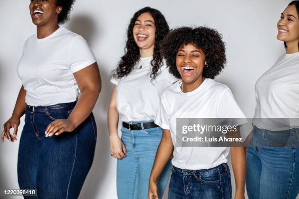group of diverse females laughing together - tshirt jeans stockfoto's en -beelden