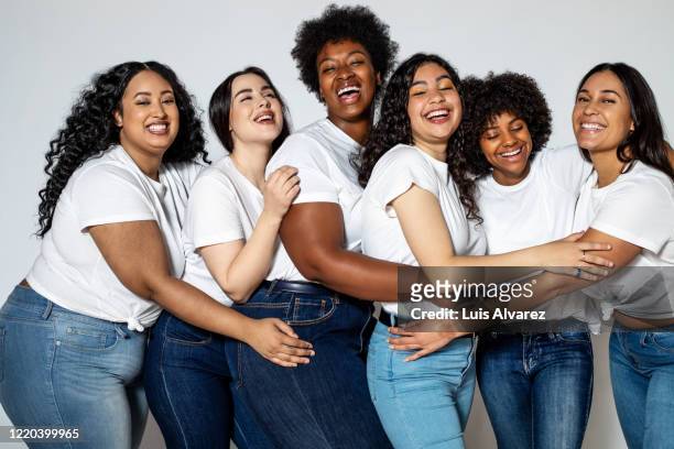 group of cheerful women with different body size - jeans foto e immagini stock