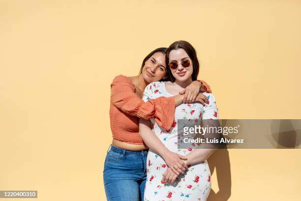 portrait of beautiful female friends standing together - vriendin stockfoto's en -beelden