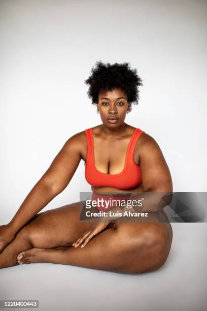 overweight woman in lingerie sitting on white background - voluptuous body stock pictures, royalty-free photos & images