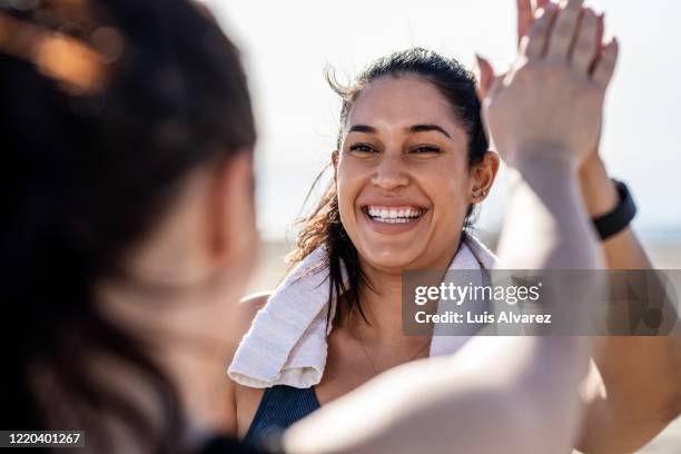 smiling woman giving high five to her friend after exercising - woman workout ストックフォトと画像