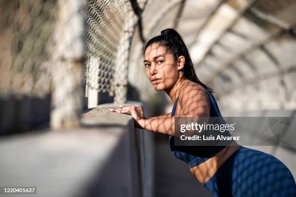 healthy woman doing some stretching workout outdoors - woman fitness focus stock pictures, royalty-free photos & images