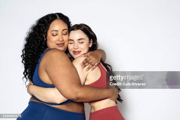 women with different weights hugging each other - beautiful plump women fotografías e imágenes de stock
