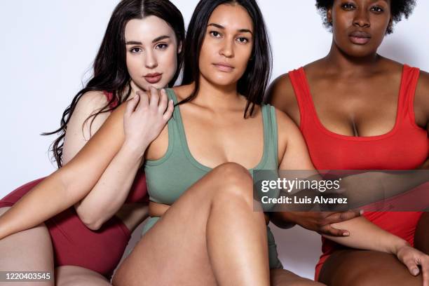multi-ethnic women in lingerie sitting together - bras photo studio stock-fotos und bilder