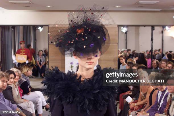 Un mannequin présente une robe de mariée noire ornée de plumes, le 15 octobre 1999 à Paris, dans le cadre du salon "Oui au Mariage" qui se tient...