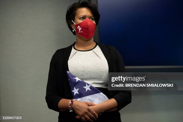 Mayor Muriel Bowser holds an American flag with 51 stars while listening during a press conference on Capitol Hill about HR51, legislation to make...