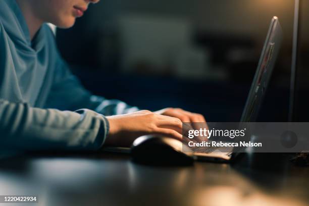 teenage boy doing school work at home - teen computer stock-fotos und bilder