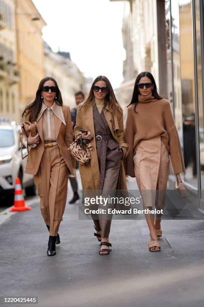 Guest wears sunglasses, earrings, a brown jacket, a brown shirt, a belt, pants, black shoes ; a guest wears a brown trench long coat, a gray jacket ;...