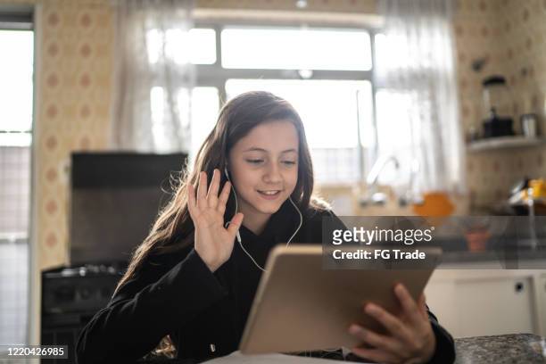 girl making a video call via tablet at home - remote location stock pictures, royalty-free photos & images