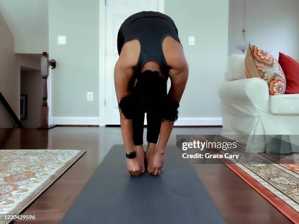 woman works out at home - touching toes stock pictures, royalty-free photos & images