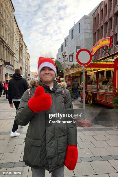 portrait of a teenage boy enjoying christmas holiday. - christmas market in munich stock-fotos und bilder