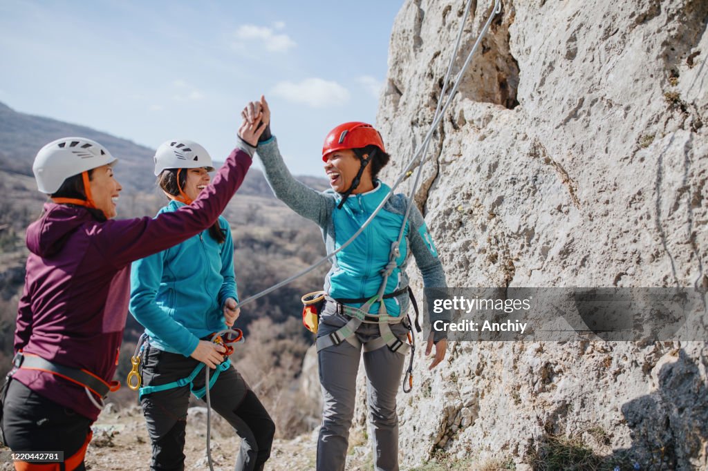 Climbers giving high fives after successfully finishing climb