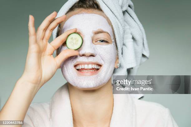 verticale de jeune belle femme avec un masque facial ayant un traitement de spa à la maison - new age concept photos et images de collection