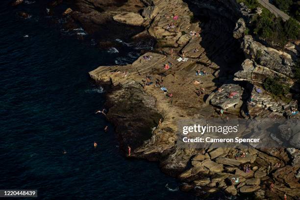 People are seen on rocks at the South end of Bondi Beach on April 22, 2020 in Sydney, Australia. Restrictions have been placed on all non-essential...