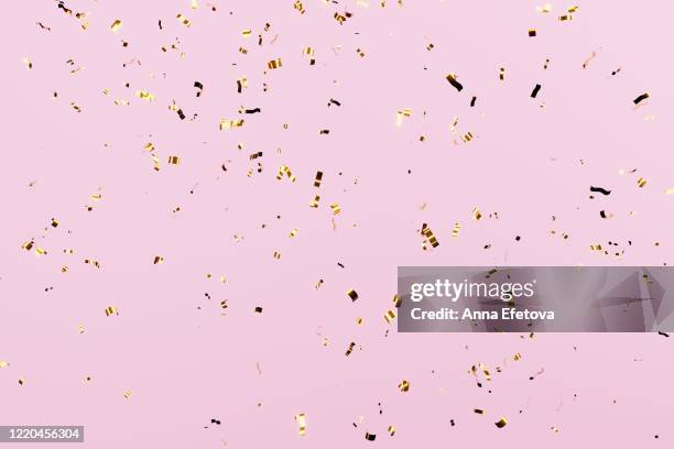 golden confetti falling over pink pastel background - pastel confetti stock pictures, royalty-free photos & images