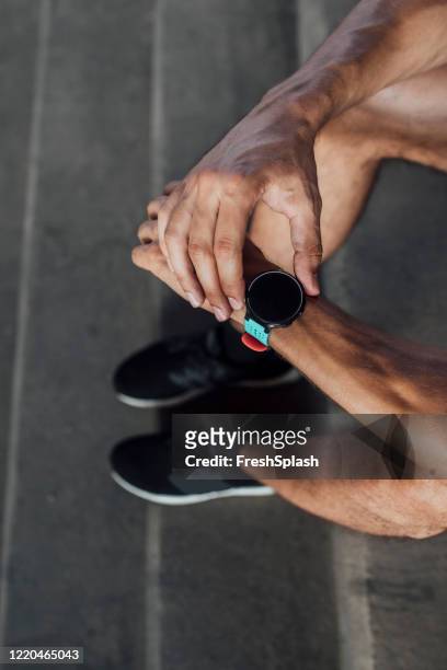 anonymous runner takes his pulse on a smartwatch, a close up - male feet on face stock pictures, royalty-free photos & images