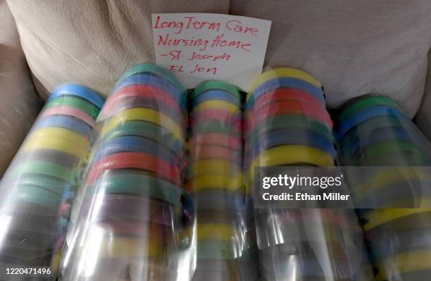 Completed, custom-made face shields for health care workers at a nursing home are stacked on a couch at the home of UNLV School of Nursing assistant...