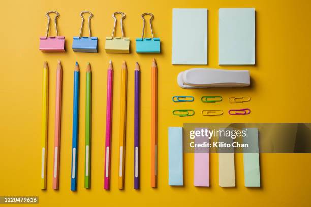 office supplies flat lay on yellow background - tacler stock-fotos und bilder