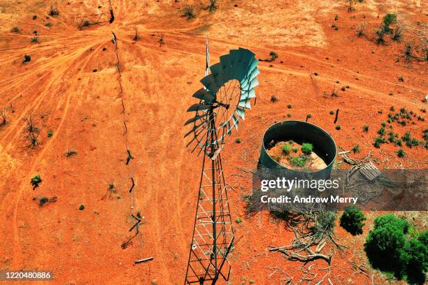 windmill, windpump and empty water storage tank on farm with red dirt field, australia, aerial view - red dirt stock pictures, royalty-free photos & images