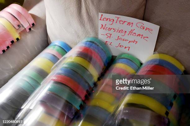 Completed, custom-made face shields for health care workers at a nursing home are stacked on a couch at the home of UNLV School of Nursing assistant...