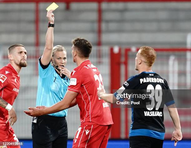 Referee Bibiana Steinhaus shows Grischa Prömel of Union Berlin the yellow card during the Bundesliga match between 1. FC Union Berlin and SC...