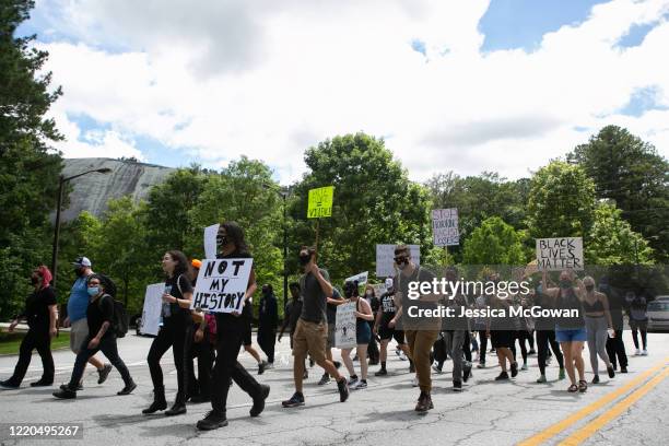 Black Lives Matter protesters lead a march into Stone Mountain Park to the Confederate carving etched into the stone side of the mountain on June 16,...