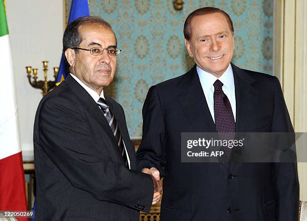 Italian PM Silvio Berlusconi shakes hands with deputy leader of Libya's rebel National Transitional Council Mahmud Jibril, in Milan on August 25...