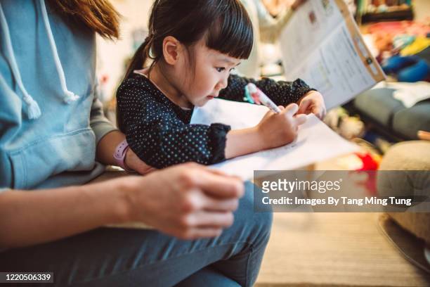 mom helping her little daughter with homework at home. - chinese tutor study stock pictures, royalty-free photos & images