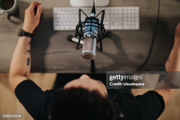 high angel view of a podcaster behind microphone - auscultador equipamento áudio imagens e fotografias de stock