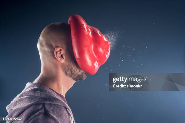 water balloon exploding on man's face - blowing up balloon stock pictures, royalty-free photos & images